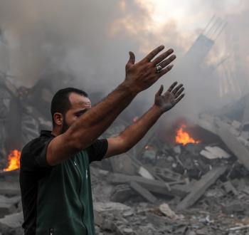 فلسطيني يقف قرب منزله المدمر بفعل غارة إسرائيلية في غزة.jpg