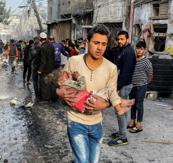 شاب فلسطيني ينقل طفلة شهيدة عقب مجزرة إسرائيلية في قطاع غزة