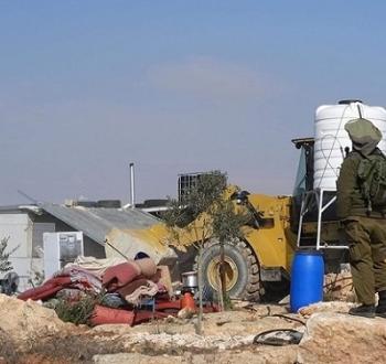 جندي من قوات الاحتلال يحرس جرافة إسرائيلية خلال عملية هدم لمنزل فلسطيني في الضفة الغربية.jpg