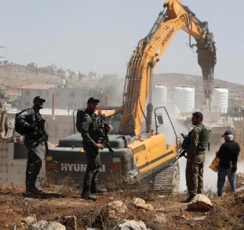جنود الاحتلال يوفرون الحماية لآلية إسرائيلية خلال هدم منشأة فلسطينية