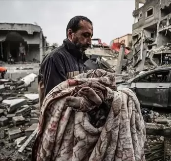 فلسطيني ينقل جثمان طفل بعد مجزرة إسرائيلية في غزة.webp