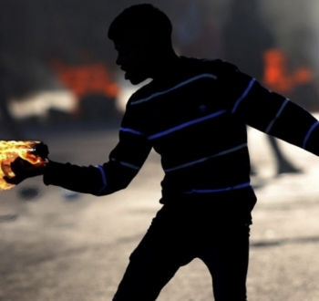 شاب فلسطيني يُلقي مولوتوف على قوات الاحتلال خلال مواجهات في الضفة الغربية