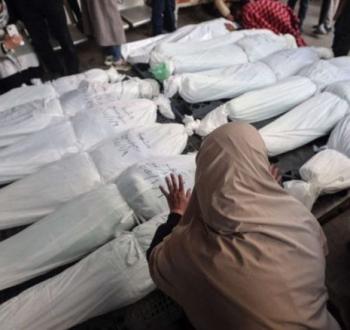 سيدة فلسطينية أمام جثامين شهداء من عائلتها ارتقوا في مجزرة بقطاع غزة.jpg