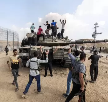 فلسطينيون يعتلون دبابة إسرائيلية على حدود غزة.webp