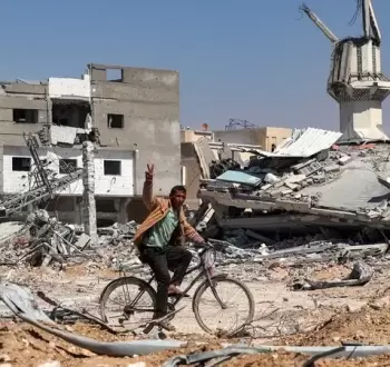 فلسطيني يرفع شارة النصر من بين الدمار في غزة.webp
