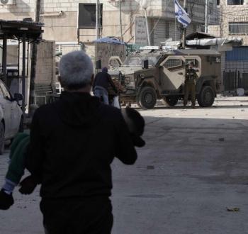 مواطن فلسطيني ينقل طفلا مصابا برصاص الاحتلال.jpg