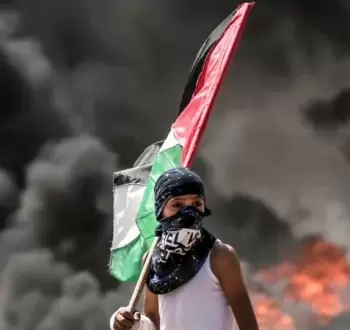 طفل فلسطيني يحمل علم فلسطين خلال مواجهات في الضفة.webp