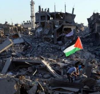 رفع علم فلسطين على أنقاض منازل مدمرة في غزة.jpg