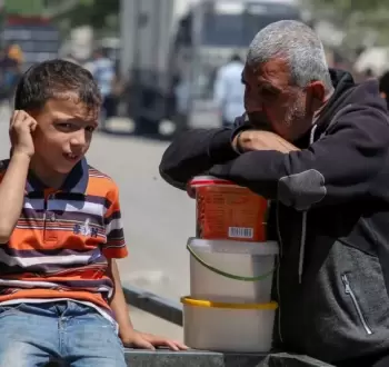 فلسطيني وطفله خلال انتظار مساعدات في غزة.webp