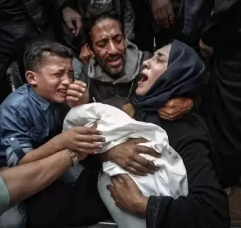 فلسطينية تحتضن طفلها للمرة الأخيرة بعد استشهاده بمجزرة إسرائيلية في غزة