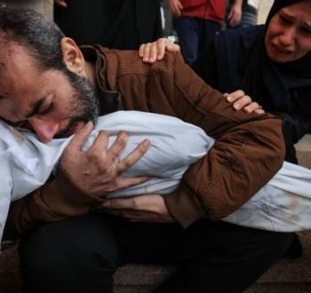 فلسطيني يودع طفلته التي استشهدت بمجزرة إسرائيلية في غزة.jpg