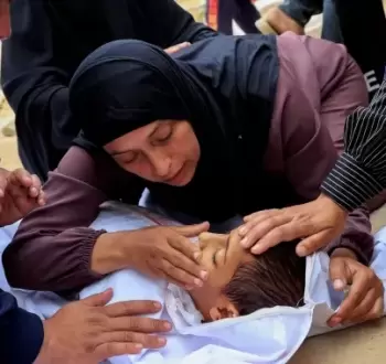 سيدة فلسطينية في غزة تودعها طفلها الشهيد.webp
