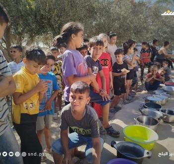 مواطنون يتجمعون للحصول على الطعام من تكية خيرية في دير البلح وسط قطاع غزة.10.jpg