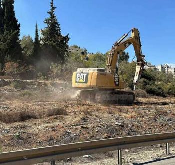 جرافة إسرائيلية تقوم بعمليات تجريف في أراض فلسطينية.jpg