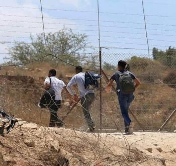 عمال فلسطينيون يجتازون جدار الفصل في الضفة الغربية.jpg