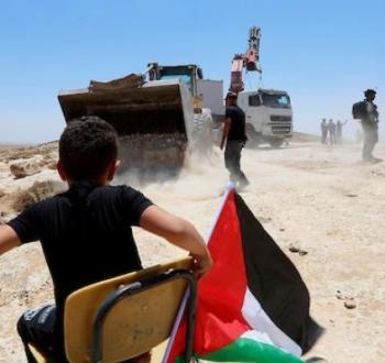 طفل فلسطيني يجلس على مقعد دراسي في مسافر يطا.jpg