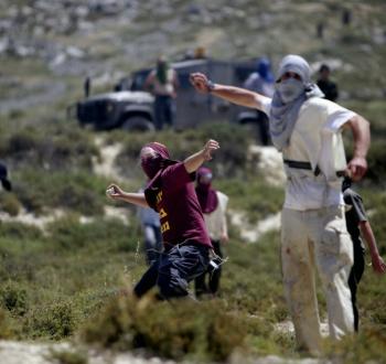مستوطنون يلقون الحجارة على فلسطينيين.jpeg