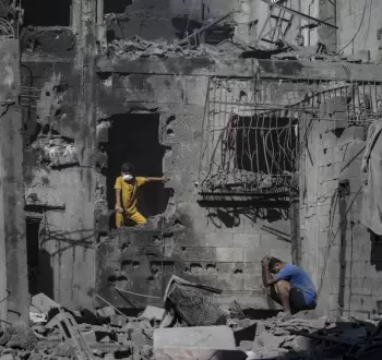 مواطنون على أنقاض منزل في غزة