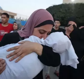 سيدة فلسطينية تودع طفلها الشهيد في غزة.webp