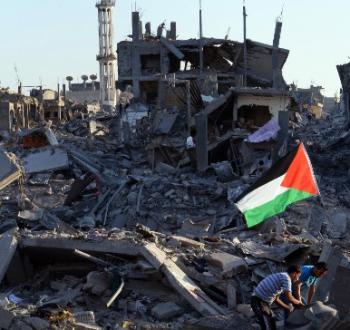 طفلان يرفعان علم فلسطين وسط الدمار في غزة.jpg