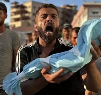 مواطن يحمل جنين قتله الاحتلال في غزة