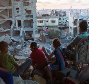 عائلة فلسطينية على أنقاض منزلها في قطاع غزة.jpg