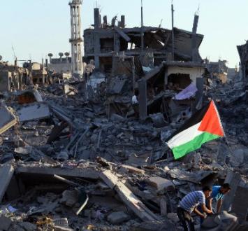 طفلان يرفعان علم فلسطين وسط الدمار في غزة