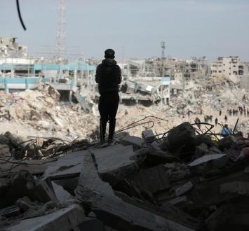 طفل فلسطيني يقف وسط أنقاض مبان مدمرة في قطاع غزة.jpg