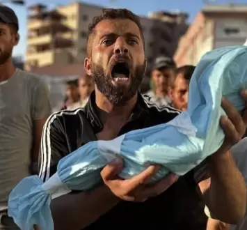 مواطن يحمل جنين قتله الاحتلال في غزة