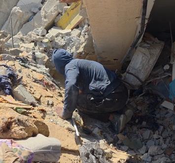 بين أنقاض منزله بخان يونس، يبحث عبد الرحمن عن فراش وأغطية لخيمته في المواصي