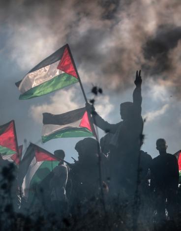 فلسطينيون يرفعون علم فلسطين في غزة مع شارة النصر.jpg