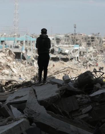 طفل فلسطيني يقف وسط أنقاض مبان مدمرة في قطاع غزة.jpg