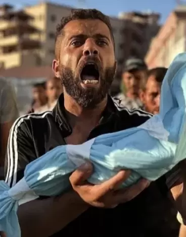 مواطن يحمل جنين قتله الاحتلال في غزة.webp