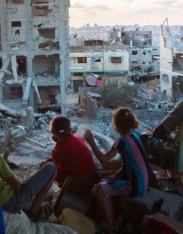 عائلة فلسطينية على أنقاض منزلها في قطاع غزة.jpg