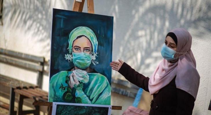 مواطنة فلسطينية تقوم برسم صورة للتأكيد على ضرورة لبس القناع الواقي من فيروس كورونا