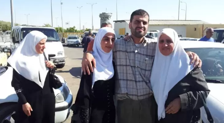 عدنان عصفور يتوسط عائلته بعد الإفراج عنه.webp