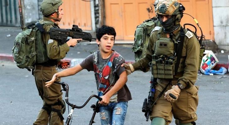 جنود الاحتلال خلال اعتقال طفل فلسطيني في الخليل رفقة دراجته الهوائية.jpg