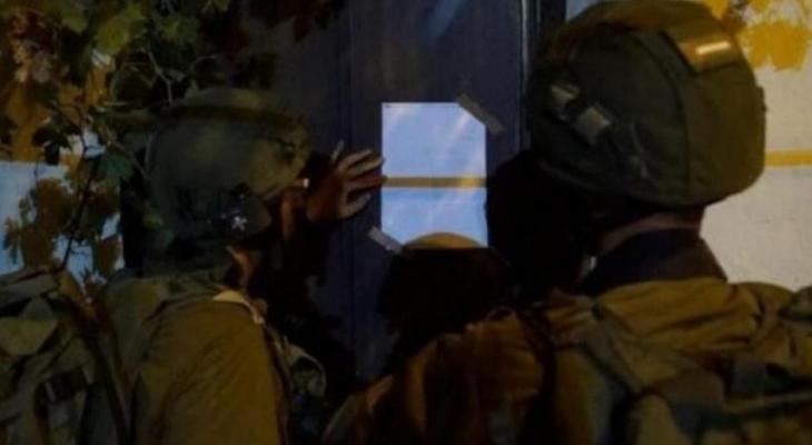 جنود الاحتلال يلصقون إخطار هدم على منزل فلسطيني.jpg