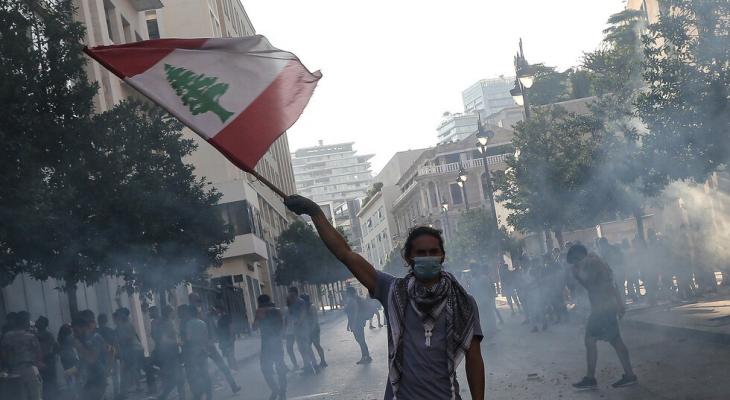 لبناني يرفع علم بلاده في فعالية احتجاجية على الأوضاع في لبنان.jpg