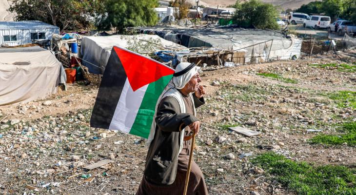 مُسن فلسطيني يحمل علم فلسطين في الخان الأحمر.jpeg