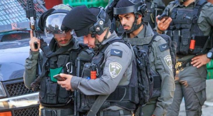 جنود من حرس الحدود يتفحصون بطاقة شاب فلسطيني.jpeg