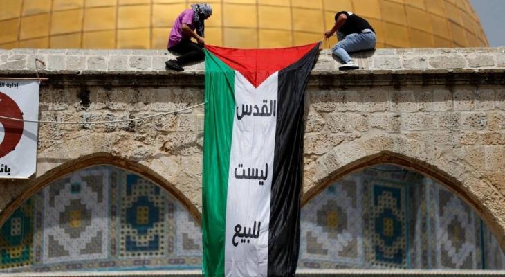 شبان يعلقون علم فلسطين على مسجد قبة الصخرة.jpg