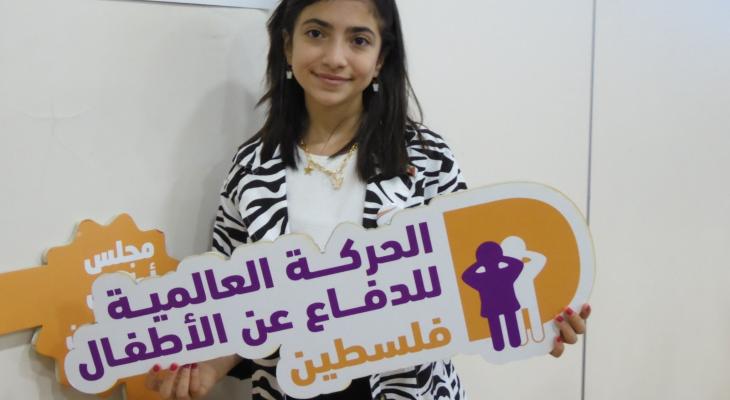 طفلة تحمل شعار الحركة العالمية للدفاع عن الأطفال- فلسطين.jpg