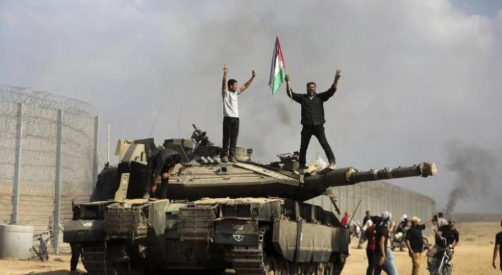 فلسطينيون يعتلون دبابة إسرائيلية بعد تفجيرها.jpeg