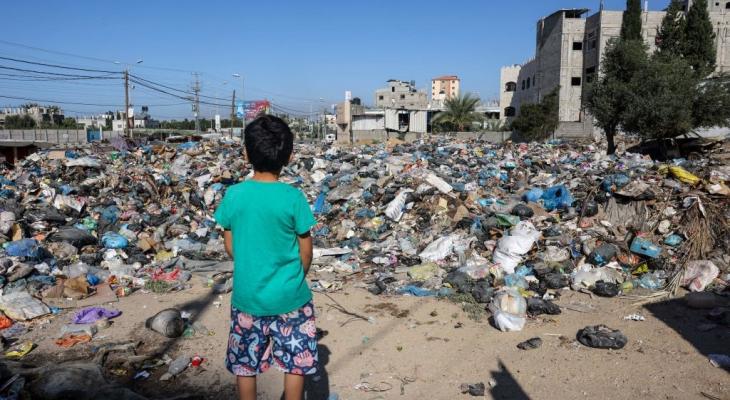 طفل أمام أكوامن من النفايات في قطاع غزة.jpg