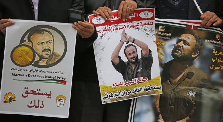 رفع صور الأسير مروان البرغوثي خلال فعالية تضامنية مع الأسرى في رام الله.jpeg