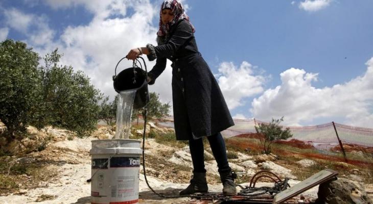 مواطنة فلسطينية تملأ الماء من بئر في الأغوار.jpg