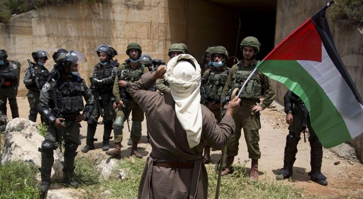 حاج فلسطيني يواجه جنود الاحتلال المدججين بالسلاح.jpg