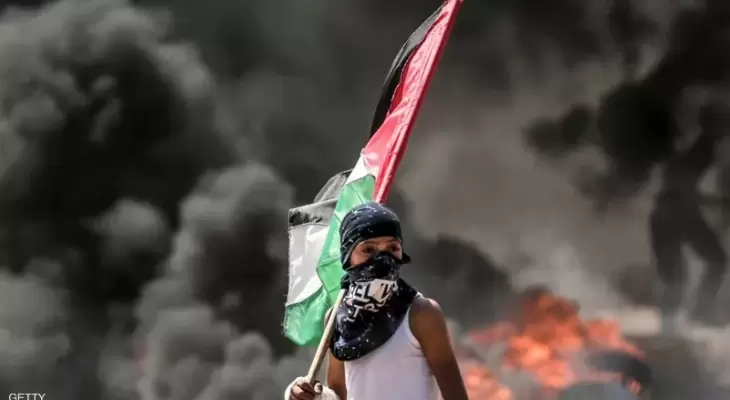طفل فلسطيني يحمل علم فلسطين خلال مواجهات في الضفة.webp
