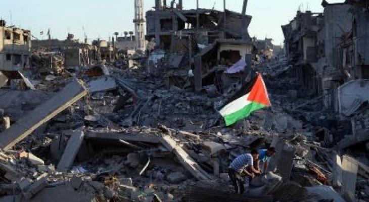رفع علم فلسطين على أنقاض منازل مدمرة في غزة.jpg